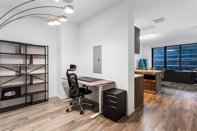 home office featuring electric panel and hardwood / wood-style flooring