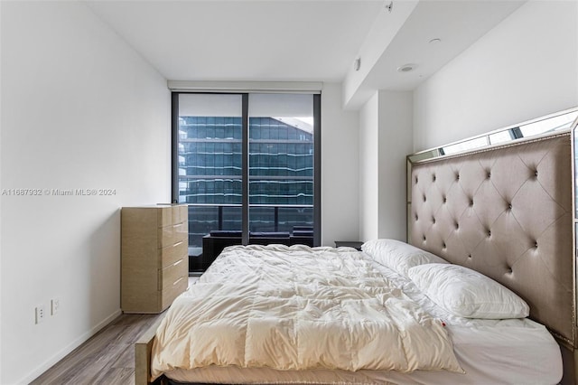 bedroom with wood-type flooring and floor to ceiling windows