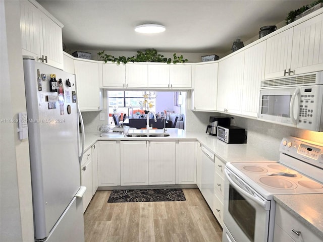 kitchen featuring sink, white cabinets, light hardwood / wood-style flooring, and white appliances