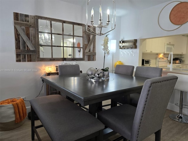 dining space with a notable chandelier and hardwood / wood-style flooring