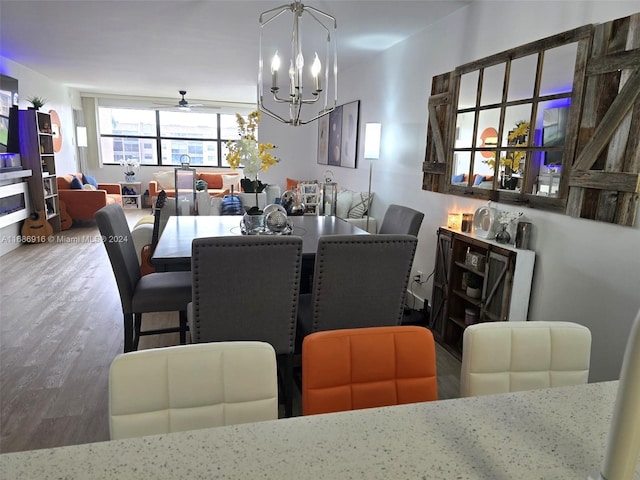 dining area featuring hardwood / wood-style floors and ceiling fan with notable chandelier