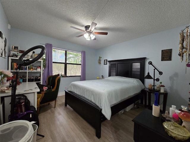 bedroom featuring a textured ceiling, light wood-type flooring, and ceiling fan