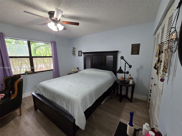 bedroom featuring a textured ceiling, wood-type flooring, and ceiling fan