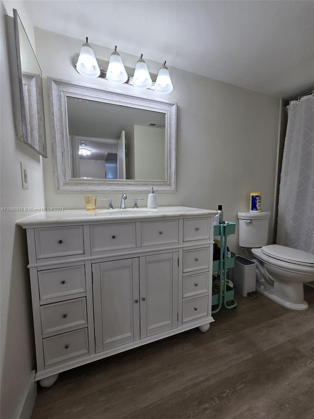 bathroom with vanity, toilet, and hardwood / wood-style flooring