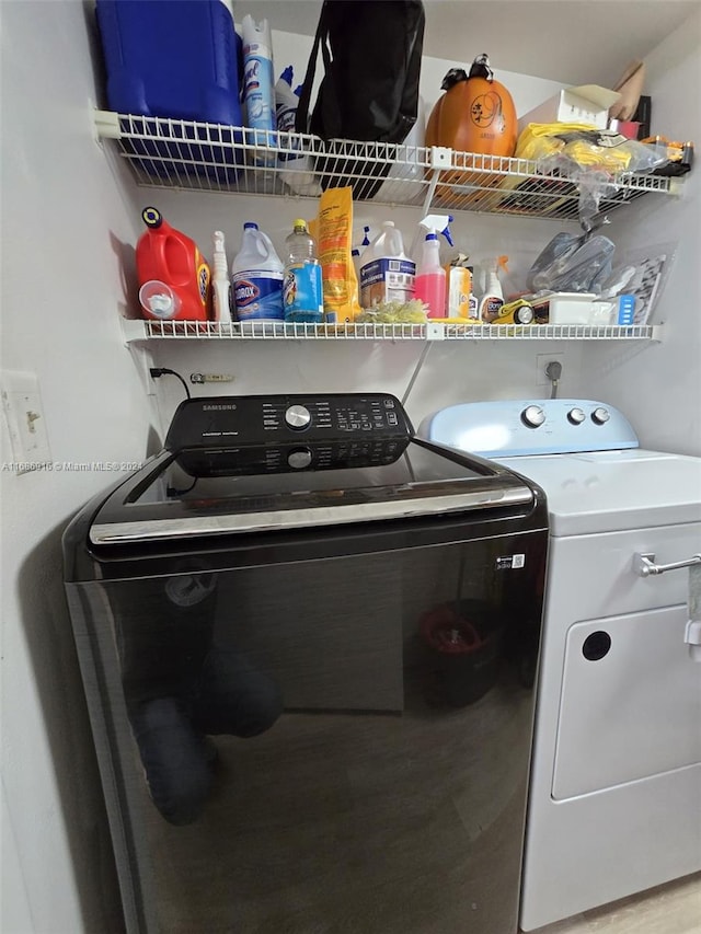 clothes washing area with washer and dryer and hardwood / wood-style floors