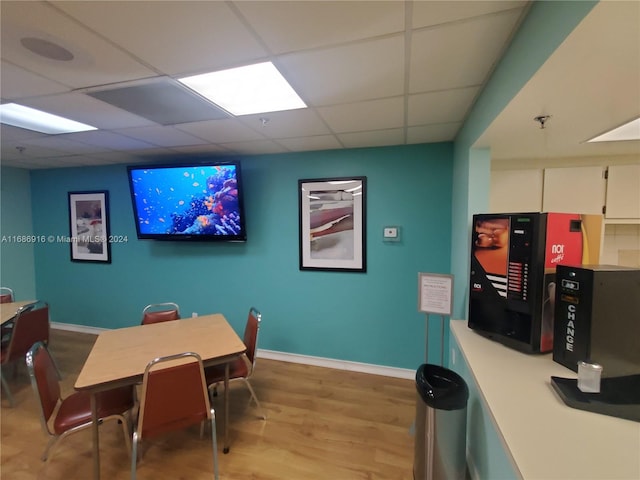 dining area featuring a drop ceiling and light hardwood / wood-style flooring