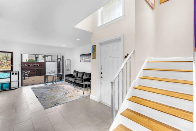 entryway featuring light tile patterned flooring and a high ceiling