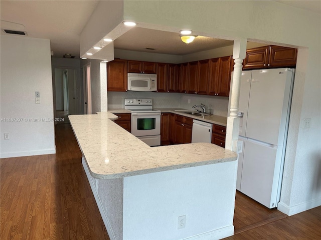 kitchen featuring white appliances, sink, a kitchen island, and dark hardwood / wood-style flooring