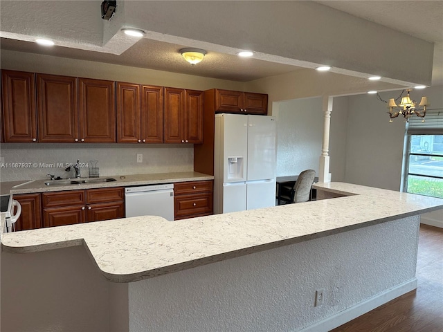 kitchen with a kitchen island, white appliances, dark hardwood / wood-style floors, sink, and a chandelier