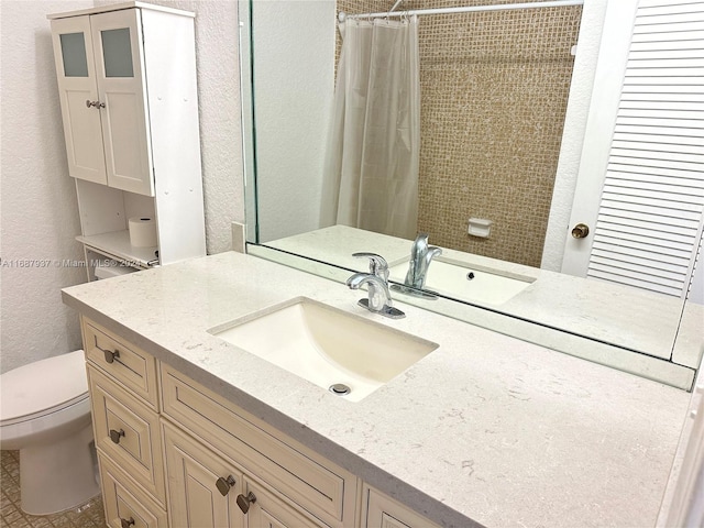 bathroom featuring toilet, vanity, and walk in shower