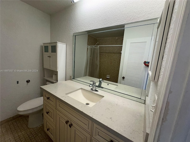 bathroom with curtained shower, tile patterned floors, vanity, and toilet