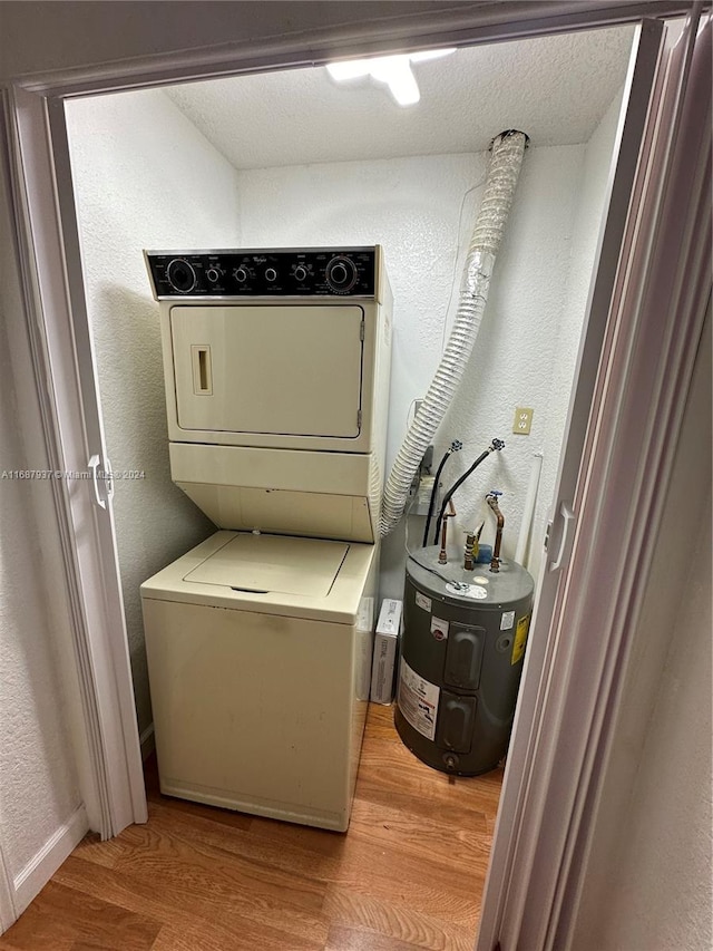 laundry area with stacked washer and dryer, light hardwood / wood-style flooring, and a textured ceiling