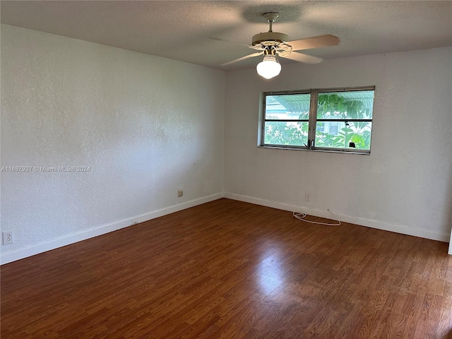 unfurnished room with dark hardwood / wood-style flooring, a textured ceiling, and ceiling fan