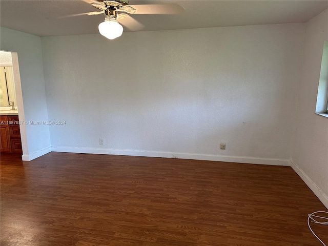 spare room with dark wood-type flooring and ceiling fan