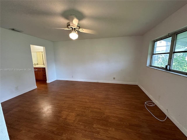 unfurnished room with dark hardwood / wood-style flooring and ceiling fan