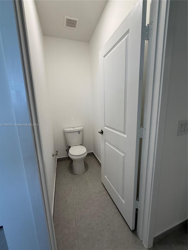 bathroom featuring toilet and tile patterned flooring