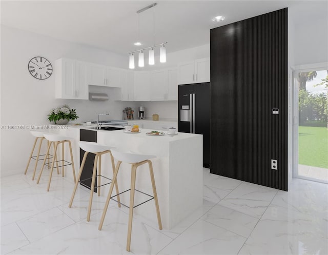 kitchen with white cabinets, a center island with sink, rail lighting, a kitchen bar, and pendant lighting