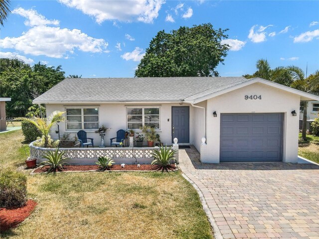 9404 NW 70th Pl, Tamarac, FL 33321 - ranch-style house featuring a garage, a front lawn, stucco siding, decorative driveway, and a shingled roof