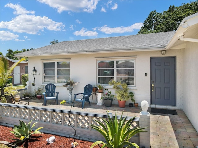 view of exterior entry with a patio