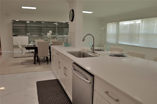 kitchen with white cabinetry, dishwasher, and sink