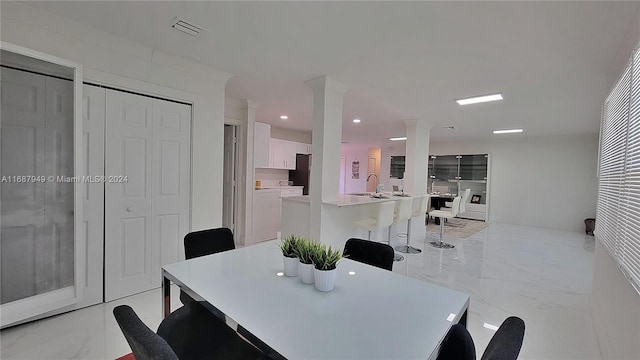 dining area featuring sink and ornate columns