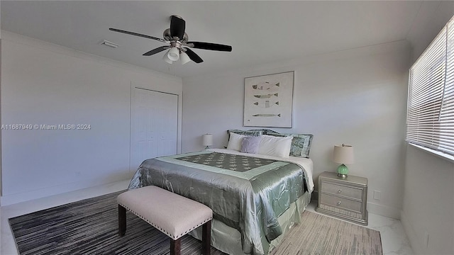 bedroom featuring a closet, ceiling fan, and crown molding