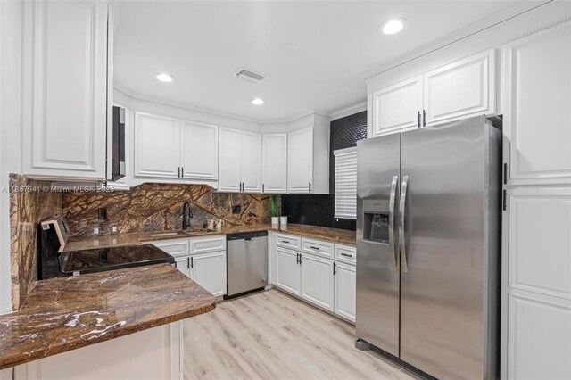 kitchen featuring kitchen peninsula, appliances with stainless steel finishes, backsplash, sink, and white cabinets