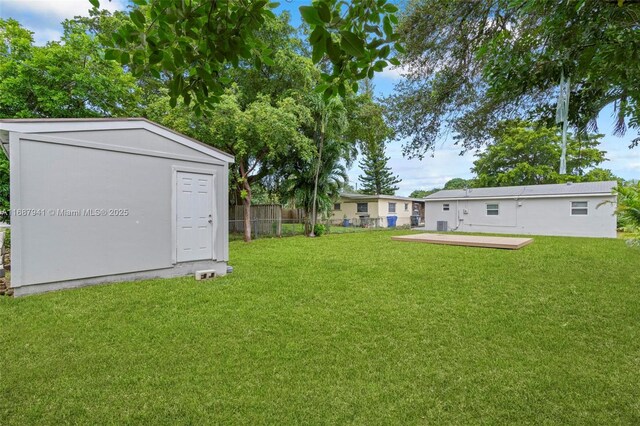 view of yard with a wooden deck and a storage unit