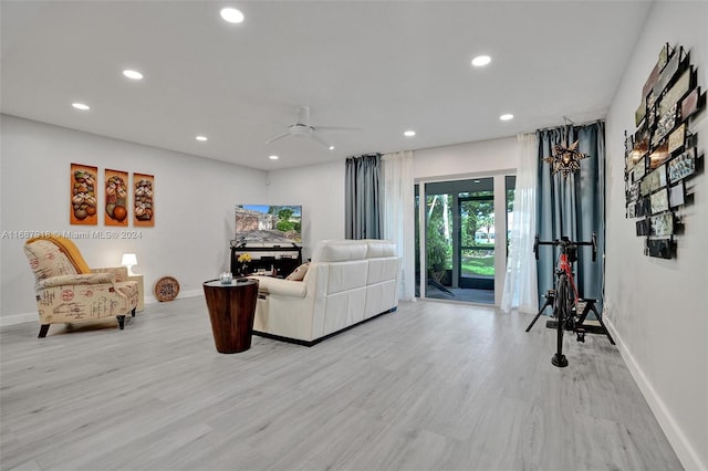 living room with ceiling fan and light hardwood / wood-style floors