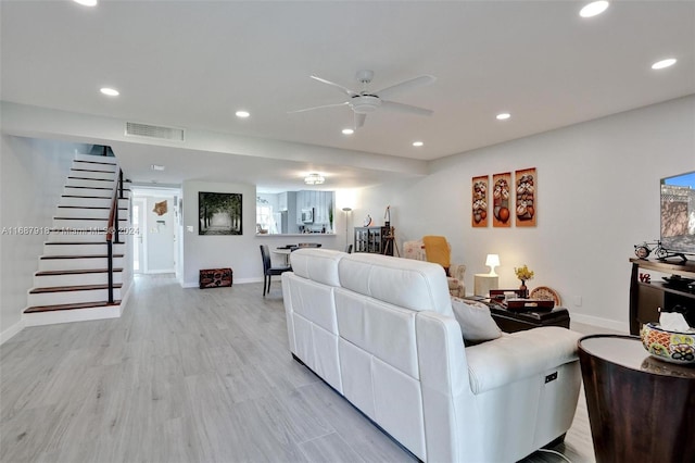 living room featuring light hardwood / wood-style flooring and ceiling fan