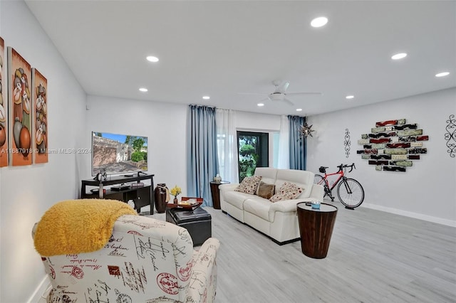 living room featuring light hardwood / wood-style floors and ceiling fan