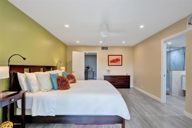 bedroom featuring light wood-type flooring, ceiling fan, and ensuite bath