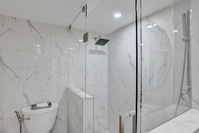 bathroom featuring toilet, tile walls, and tiled shower