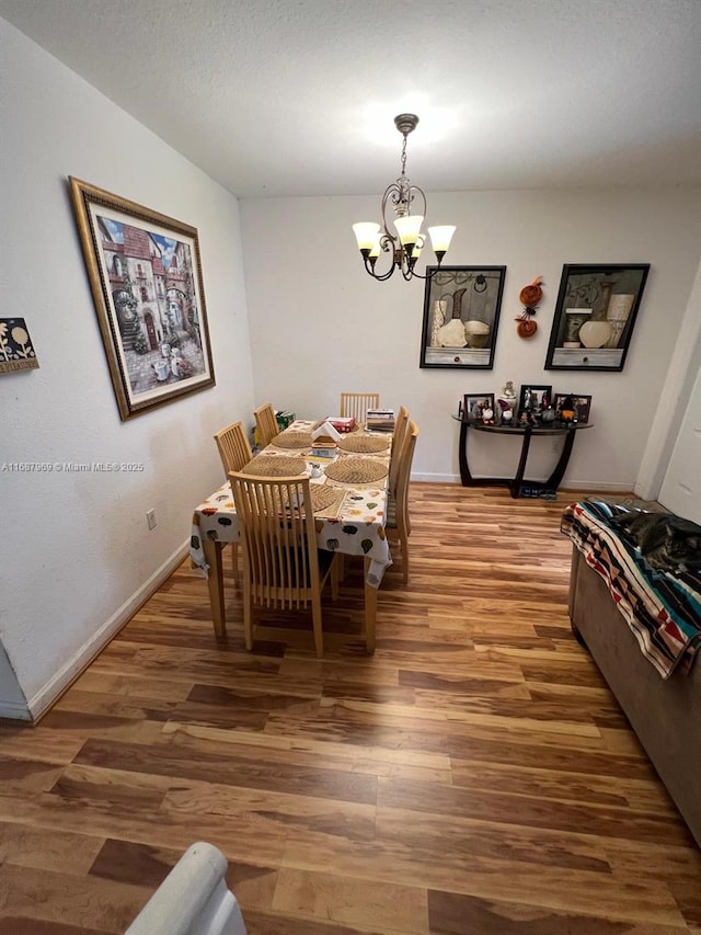 dining room with hardwood / wood-style flooring and a notable chandelier