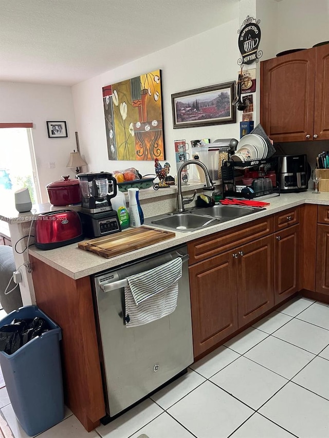 kitchen featuring dishwasher, sink, and light tile patterned floors