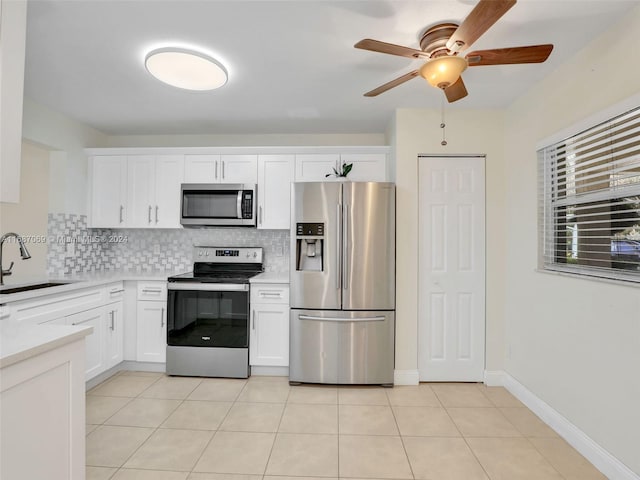 kitchen featuring white cabinetry, sink, appliances with stainless steel finishes, light tile patterned floors, and decorative backsplash