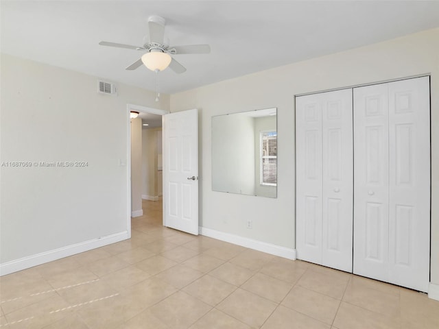 unfurnished bedroom featuring light tile patterned flooring, ceiling fan, and a closet