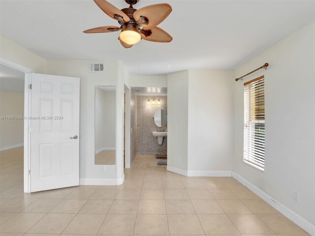 tiled empty room featuring ceiling fan