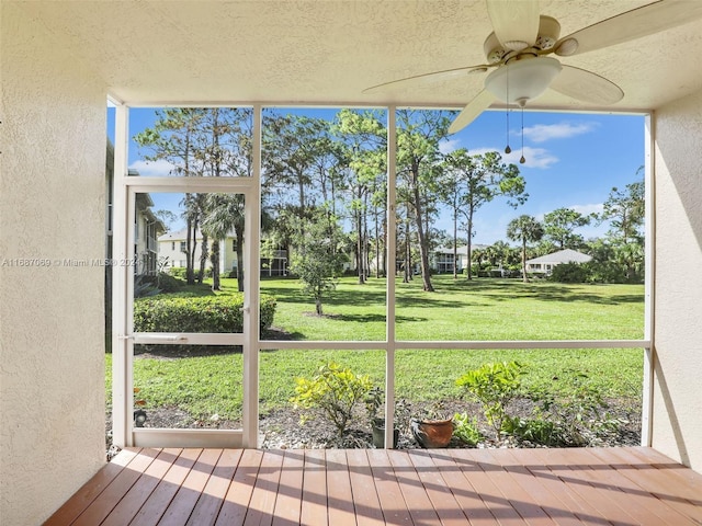 unfurnished sunroom with ceiling fan