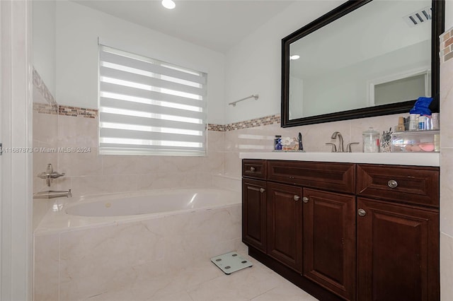 bathroom featuring tile patterned flooring, vanity, tile walls, and tiled bath