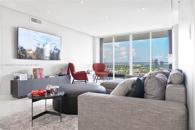 living room with a wall of windows and light tile patterned floors