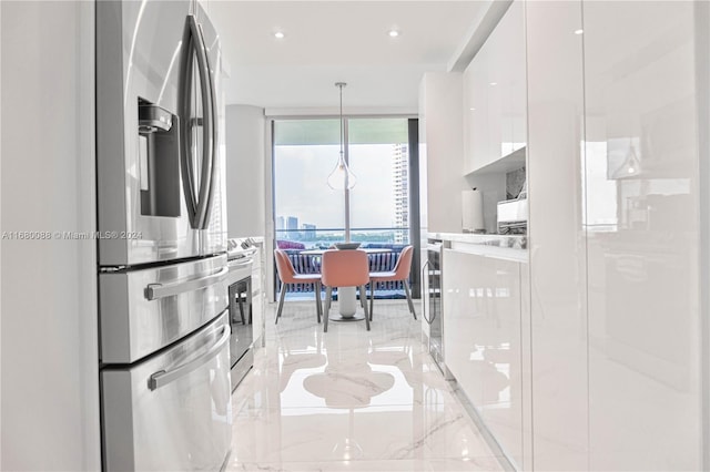 kitchen featuring stainless steel appliances, white cabinetry, and decorative light fixtures