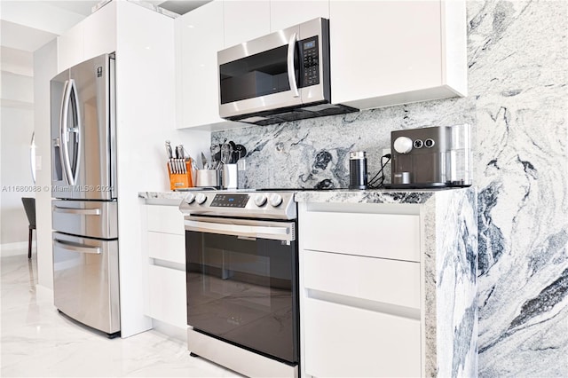 kitchen featuring white cabinets, decorative backsplash, and stainless steel appliances