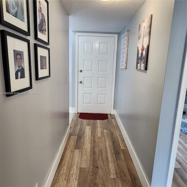 corridor featuring hardwood / wood-style floors and a textured ceiling