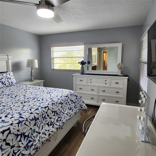 bedroom with ceiling fan, dark hardwood / wood-style floors, and a textured ceiling