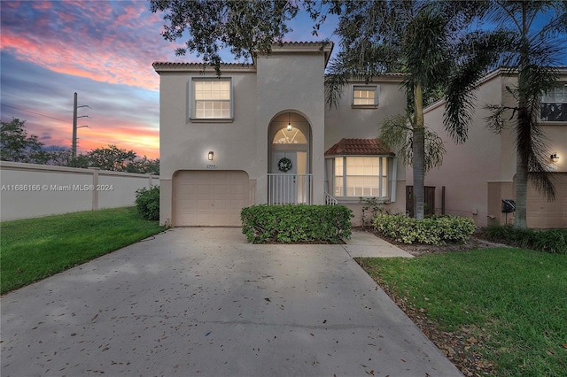 mediterranean / spanish-style home with a lawn and a garage