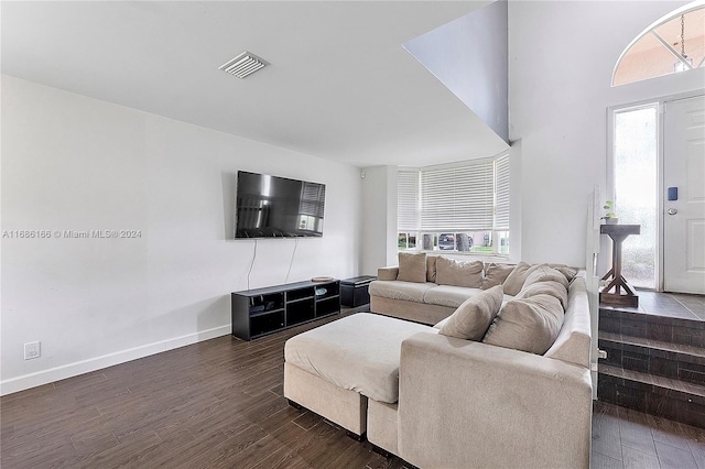 living room with dark wood-type flooring and a healthy amount of sunlight