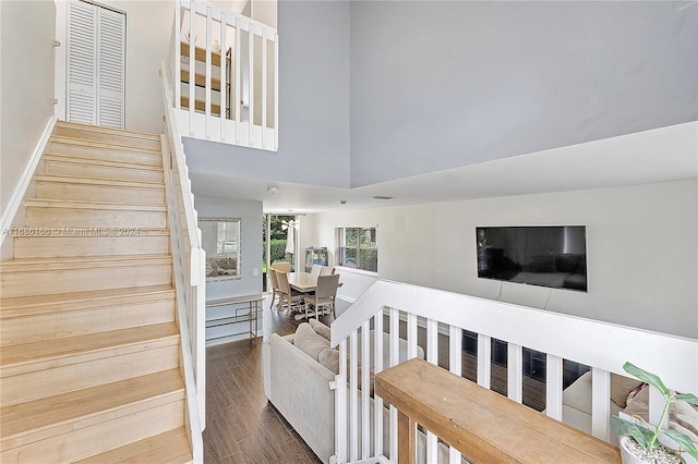 stairway featuring hardwood / wood-style flooring and a high ceiling