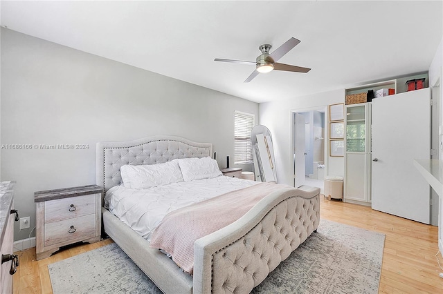 bedroom with light hardwood / wood-style floors, ceiling fan, and connected bathroom