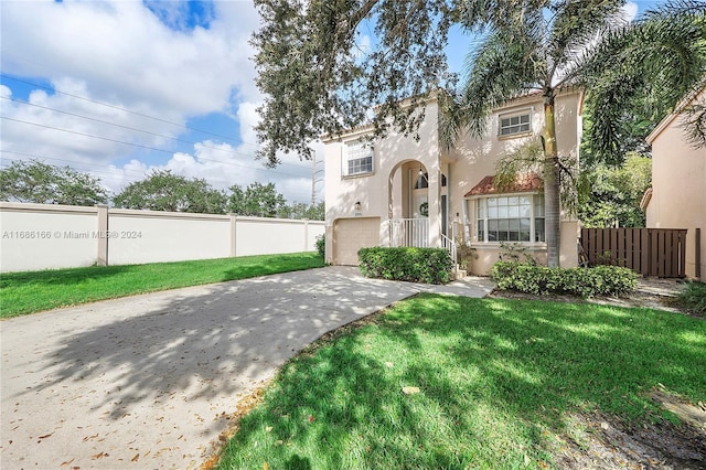 mediterranean / spanish-style home featuring a garage and a front yard